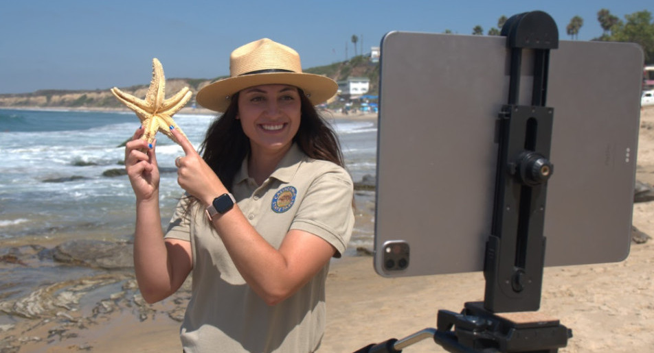 An interpreter is holding a sea star during a virtual PORTS presentation