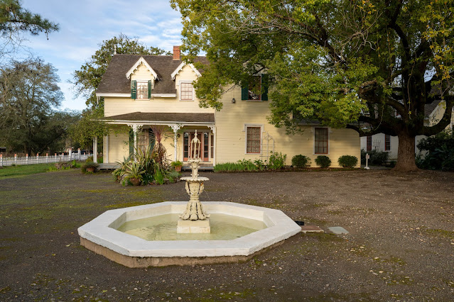 Vallejo Home, Sonoma SHP Photograph of the main façade of a two-story Victorian home set within a formal garden featuring a mature tree and an octagonal fountain.