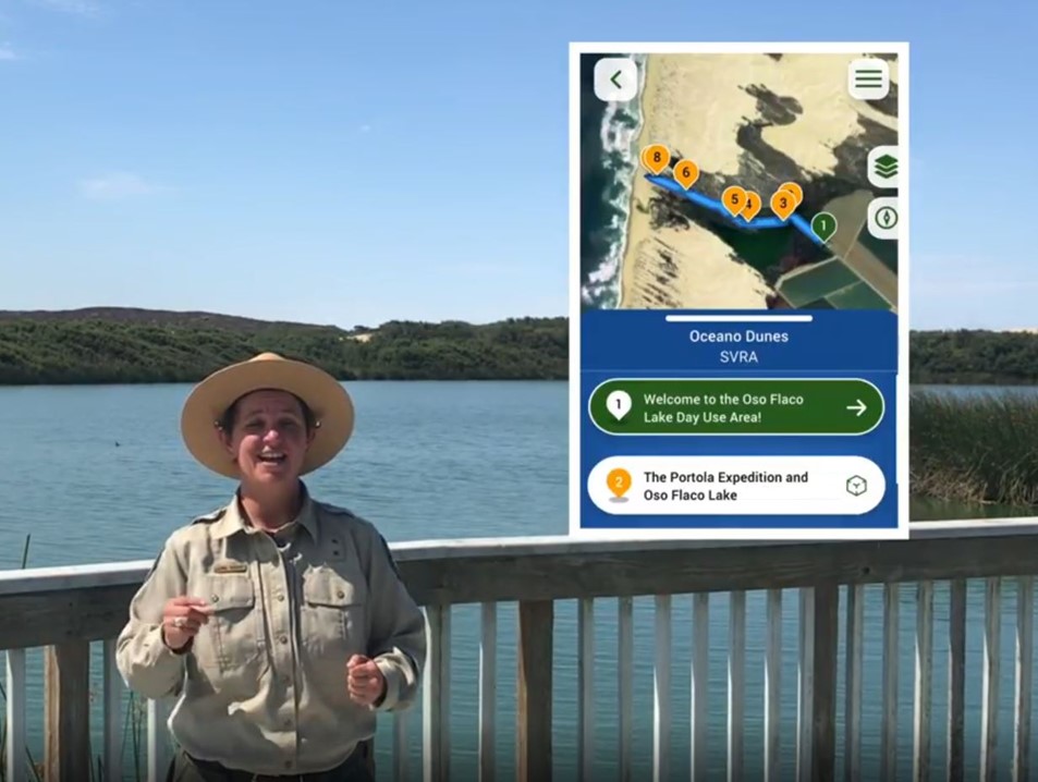 Collage of a photo of a uniformed California State Park Interpreter at Oceano Dunes State Vehicular Recreation Area  standing against a wooden deck railing with a lake and vegetated sand dunes behind her; inset within the photo is a screenshot of the Virtual Adventurer app.