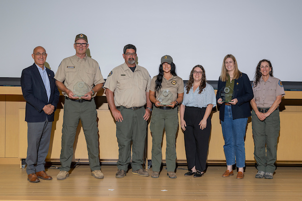 Directors Awards--3/26/26<br />
Photo by Brian Baer Photograph of people, some in parks uniforms and others in business casual wear, standing in line on a stage accepting a group award.